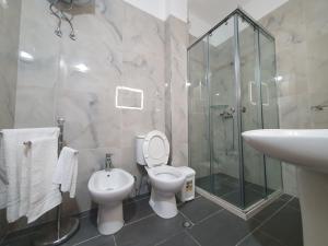 a bathroom with a toilet and a sink and a shower at Seaview Apartments in Vlorë +31 photos