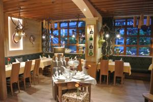 a dining room with tables and chairs and windows at Spessart-Lodge in Weibersbrunn