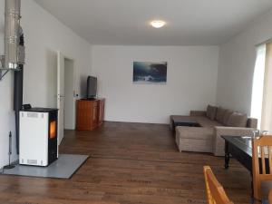 a living room with a couch and a tv at Westerwald Apartments in Straßenhaus