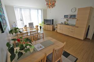 a living room with a table and chairs and a kitchen at Hotell Munkeröd in Stenungsund