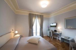 a bedroom with a bed and a desk and a television at Aquae Sinis Albergo Diffuso in Càbras