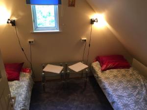 two beds in a room with a table and a window at Vahtra Vacation Houses in Käsmu
