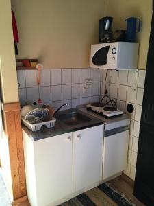 a small kitchen with a sink and a microwave at Vahtra Vacation Houses in Käsmu