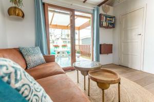 a living room with a couch and a table at House boat studio with waterfront terrace in Amsterdam