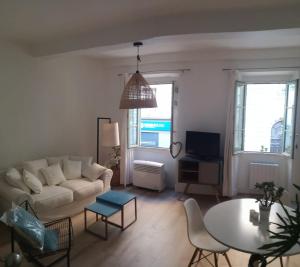 sala de estar con sofá y mesa en Joli appartement niçois en bord de mer en Niza