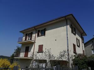 a white building with a balcony on the side of it at Mille papaveri rossi Casa di Angela in Serravalle di Chienti