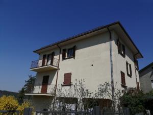a white building with a balcony on the side of it at Mille papaveri rossi Casa di Angela in Serravalle di Chienti