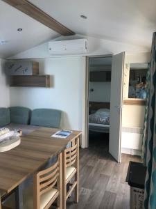 a living room with a table and a room with a bed at Mobile Home 701 in Les Mathes