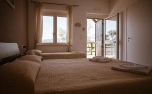 a bedroom with two beds and a large window at Agriturismo Podere Pansera in Petrizzi