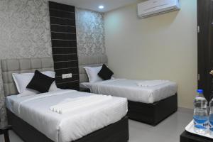 Pokój z 2 łóżkami i telewizorem w obiekcie Hotel S L E Residency w mieście Waranasi