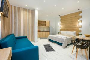 a bedroom with a bed and a blue couch at Studios Passa in Limenaria