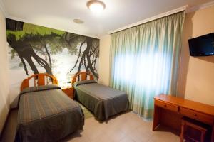 A bed or beds in a room at Hostal Restaurante Terra Chá