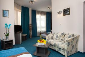 a living room with a couch and a tv at Opera Family Hotel - former City Mark hotel in Varna City +22 photos
