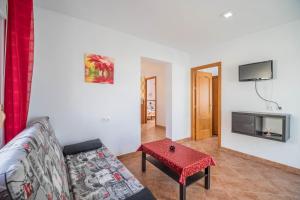 ein Wohnzimmer mit einem Sofa und einem Tisch in der Unterkunft Casa Rural La Ermita in Conil de la Frontera