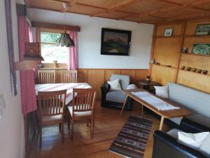 a living room with a table and a couch at Auerberg Blick in Hainfeld