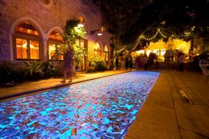 a walkway with a lit up pool in a street at night at Arthaus Beirut in Beirut