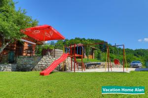 a playground with a red slide and an umbrella at Vacation home Alan 2 in Kulen Vakuf