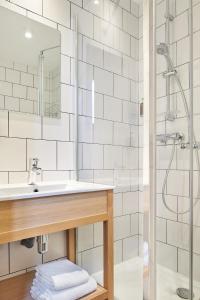 a bathroom with a sink and a shower at Hôtel Stanley by HappyCulture in Nancy