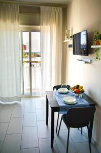 a living room with a dining room table and a television at La casa di paola in SantʼAntonio Abate