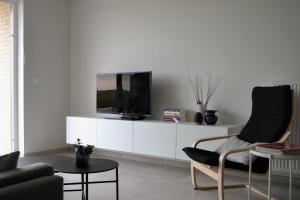 uma sala de estar com uma televisão num armário branco em Karthuizer Duinpoort em Nieuwpoort