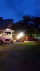 a house with a light in the yard at night at สุขกมลรับอรุณแฝด2ห้อง in Chanthaburi