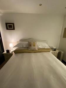 - une chambre avec un grand lit blanc et 2 oreillers dans l'établissement Cockfosters executive Mews, à Barnet