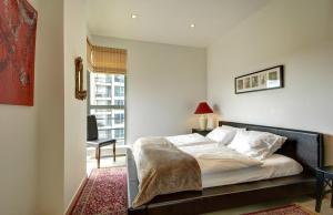 a bedroom with a bed and a desk and a window at Helios apartment in Vilnius skyscraper in Vilnius