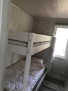 Havsutsikt i Sankt Anna في Sankt Anna: سرير بطابقين أبيض في غرفة صغيرة مع نافذة