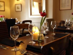a table with wine glasses and a red flower on it at Recruiting Sergeant in Norwich