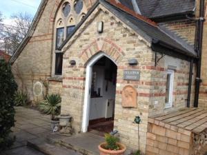 ein kleines Backsteingebäude mit Zugang zu einer Kirche in der Unterkunft Chalk and Cheese in Shouldham Thorpe