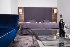 a room with a bed and a wine bottle on a table at City Boutique Hotel in Zielona Góra