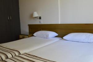 2 camas con almohadas blancas juntas en Lordos Hotel Apartments Nicosia, en Nicosia