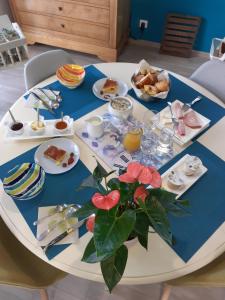 una mesa blanca con platos de comida. en Escale en baie., en Pontaubault