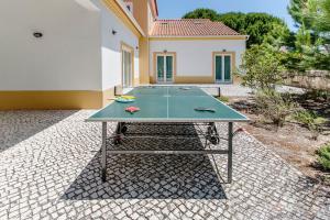 a ping pong table in front of a house at Quinta do Peru I in Quinta do Conde