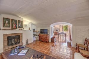 a living room with a fireplace and a tv at Sa Cabana Vella Fornalutx in Fornalutx