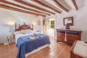a bedroom with a bed with a blue comforter at Sa Cabana Vella Fornalutx in Fornalutx