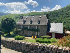 une ancienne maison en pierre avec un mur en pierre dans l'établissement Maison Jeanne, à Saint-Paul-dʼOueil