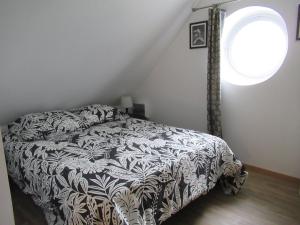 a bedroom with a bed with a black and white blanket at 6 Grenouill&egrave;re in La Madelaine-sous-Montreuil