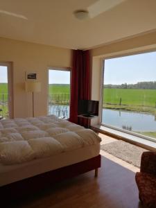 a bedroom with a large bed and a large window at Landhotel Kreien in Kreien