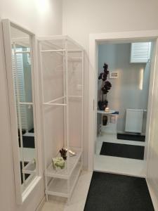 a white walk in closet with a glass door at Cicha Przystań - Apartamenty Wyspa Solna in Kołobrzeg