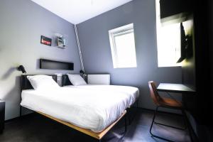 a bedroom with a large bed and a chair at The Arcade Hotel Amsterdam in Amsterdam