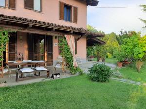 a cat sitting in the grass in front of a house at B&B Cascina Ciapilau in Asti