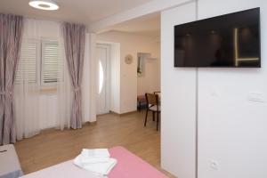 sala de estar con TV de pantalla plana en la pared en Luxury Studio Apartment Honeymoon, en Split
