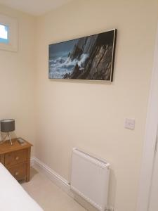 a bedroom with a picture on the wall and a radiator at Inspiration Lodge in Anascaul