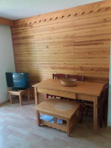 ein Esszimmer mit einem Tisch und einem TV in der Unterkunft La Foux d'Allos in La Foux