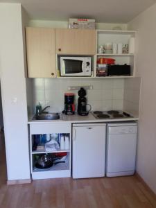 una pequeña cocina con electrodomésticos blancos y microondas en La Foux d'Allos, en La Foux