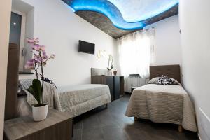 a bedroom with two beds and a blue ceiling at Golden Eagle in Agerola