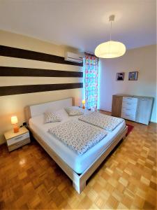 Schlafzimmer mit einem weißen Bett und Holzboden in der Unterkunft Sunset Apartment in Pula