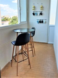 einen Tisch und zwei Stühle in einem Zimmer mit Fenster in der Unterkunft Sunset Apartment in Pula