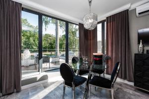 a dining room with a table and chairs and a large window at ICON APARTMENTS in Gdańsk